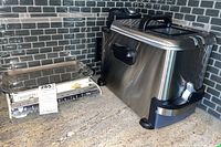 Profile view of T-Fal deep fryer next to vintage mechanical kitchen scale on countertop with gray tile backsplash.