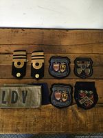 Overview of the patches, epaulettes and fabric pieces arranged on wood surface.