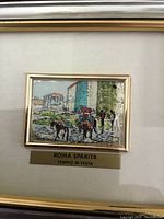 Close-up of the hand-painted sterling silver plaque showing a colored street scene with figures and horses, framed.
