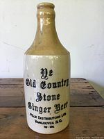 Front view of the pottery ginger beer bottle with visible labeling and some wear.