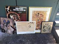 Lot contents showing three framed pictures and two prints arranged on the floor near a window, various sizes and styles visible.