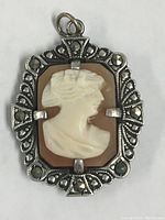 Front view of the antique cameo pendant showing the carved profile and marcasite stone decoration