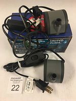Two electric water pumps model AP-125 by United Pump Inc. on original packaging, with power cords and inline switches visible.