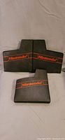 Photo showing three black plastic Nintendo cartridge sleeves with red Nintendo logo on the front.