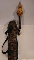 Hulusi flute in front of the decorative carrying case, showing overall lot contents