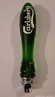 Full view of green Carlsberg beer tap handle with white logo and chrome detail