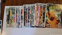 Full view of 32 DC Comics comic books spread on table including Green Lantern and others.