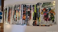 Top view showing 19 individually sleeved DC Comics New 52 comic books arranged side by side.