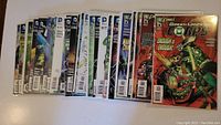 15 DC Comics Green Lantern Corps comic books laid out flat in a row, each protected in plastic sleeves