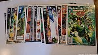 View of the full lot spread out showing 14 comic books, mostly featuring DC Comics characters.