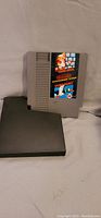 NES cartridge showing front label with Mario Brothers and Duck Hunt artwork
