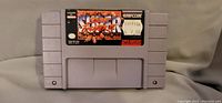 Front view of Super Street Fighter 2 cartridge showing label and Capcom branding.