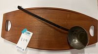 Top view of the wooden serving tray with the copper ladle resting on it, showing tray handles and ladle bowl.