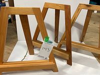 Three wooden A-frame picture easels shown standing on white background demonstrating size and style