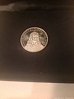 Obverse side of the silver coin showing portrait of John James Audubon with his name and dates.
