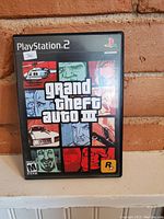 Front cover of PlayStation 2 Grand Theft Auto III game case showing artwork and ESRB rating M for Mature.