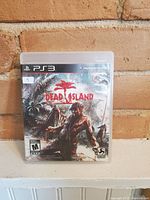 Closed case of Dead Island PS3 game showing front cover art and branding.