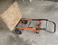 Side angle photo showing handtruck frame, wooden loading platform, and wheels.