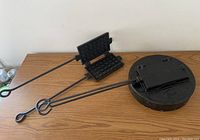 Cast iron waffle iron and pie iron laid on wooden table showing size and handle designs