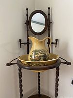 Full view of antique wooden wash stand with cream ceramic jug and bowl.