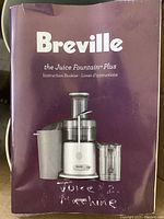 Instruction booklet with purple cover showing Breville Juice Fountain Plus branding and an image of assembled juicer