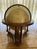 Front-facing view of the Crams Imperial World Globe showing the map and wooden stand.