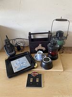 Full lot displayed on wooden table with all items visible including phone, lanterns, tray, caddy, cups, trivet, and Harley Davidson switch plate.