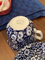 Bottom view of the Burleigh teacups showing maker's mark and the blue floral pattern.