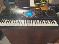 Front view of the Casio CTK-533 keyboard showing keys, built-in speakers, and control panel with LCD display.