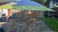 Assembled Coleman Instant Eaved Shelter with green and gray canopy on steel frame