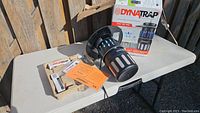 Full view of Dynatrap mosquito trap on table with original box, spare bulbs, instructions, and accessories.