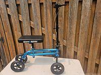 Full view of blue Knee Rover knee scooter with padded knee platform and handlebar with brakes.