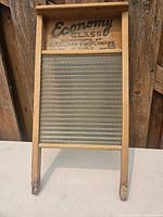 Full front view of the vintage Economy glass washboard showing the wooden frame and the textured glass surface.