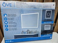 Box of OVE Andromelia dimmable LED mirror showing features including touch sensor, dimmable LED light, hardwire connection, and size 24 x 32 inches.