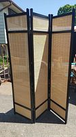 Room divider fully open showing three wood framed woven panels