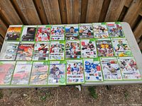 Full view of 24 Xbox 360 games spread on table showing covers.