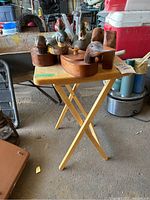 Photo showing two carved loon banks and two carved duck decoys placed on a small folding table.