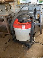 Full view of Ridgid 16 gallon shop vacuum with hose and attachment.
