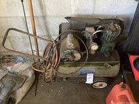 Front and side view of the vintage Sears compressor mounted on a green horizontal tank, showing the pressure gauge, motor, and hose.