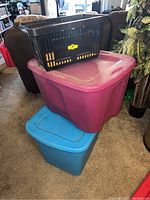 Black mini basket stacked on top of purple and blue storage bins.
