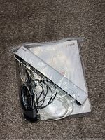 Neat compact white scanner with power adapter, cables, and user manual on carpeted floor