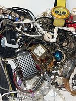 Image showing a pile of assorted costume jewelry, watches, and pocket watches including beaded necklaces, bracelets, and multiple wristwatches.