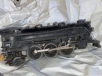 Side view of black Lionel steam locomotive number 224 showing wheels and drive rods