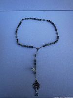 Full rosary laid out on a flat surface showing the beads and the cross.