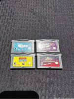 Front view of four Game Boy Advance cartridges labeled Finding Nemo, Yu-Gi-Oh!, Rocket Power, and Crimson Sea