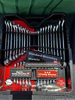 Set of standard and metric wrenches arranged in carrying case with size charts visible