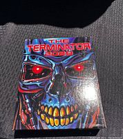 Close-up photo of The Terminator 2029 game manual showing the colorful robotic skull artwork on the cover.