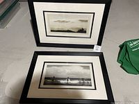 Two framed art prints by Alicia Soave displayed on floor, each in a black frame with double matting showcasing natural landscape scenes.
