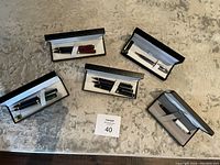 Overview showing five pen sets, each in original black cases with satin lining on carpeted floor.