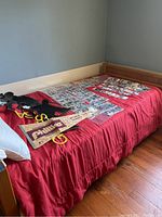Red bed with baseball cards arranged on top along with Phillies 1973 World Series pennant and Phillies cardboard cutouts.